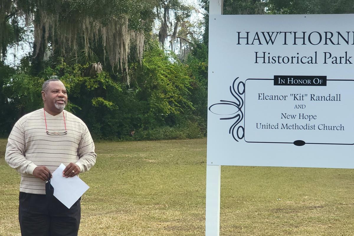 Reverend Eugene Herring, Pastor of New Hope United Methodist Church, standing in front of the new museum sign.